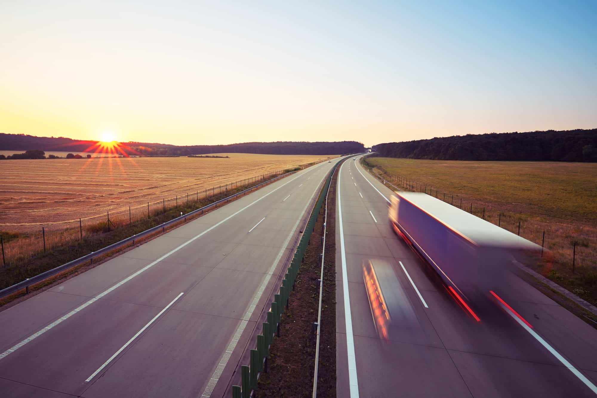 Cargo trucks on a motorway at dusk