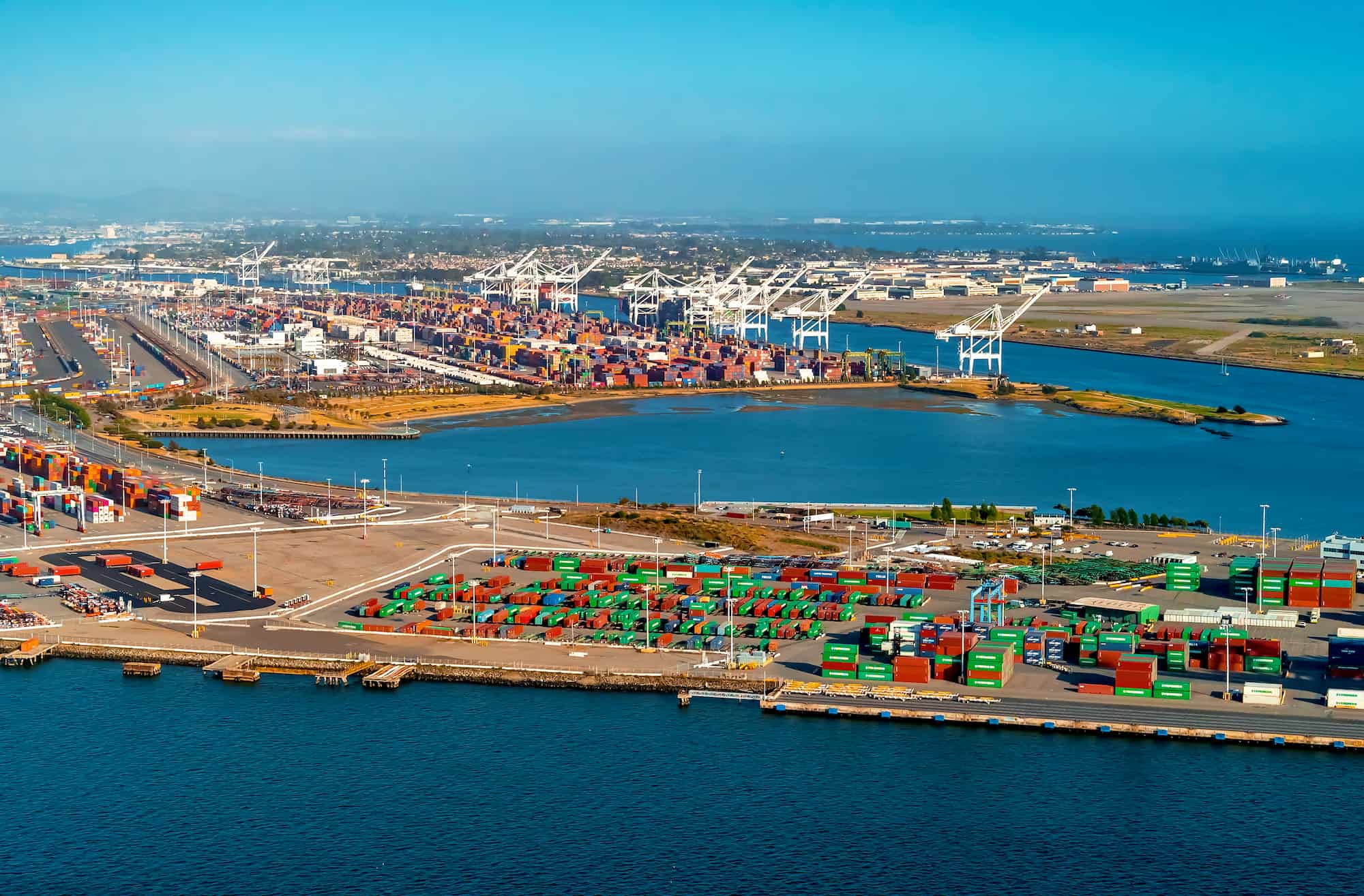 Aerial view of a freight port with green shoreline